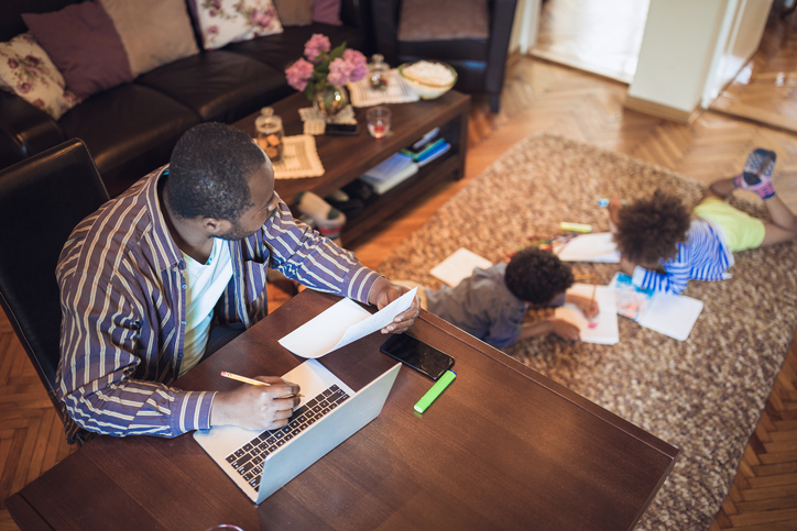 father working from home while keeping an eye on the kids