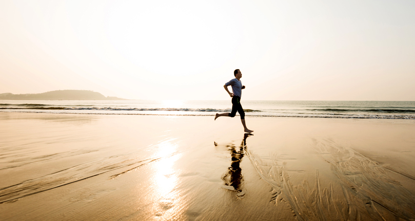 man running by himself on the beach