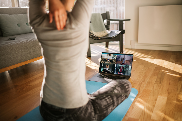 woman doing virtual yoga at home